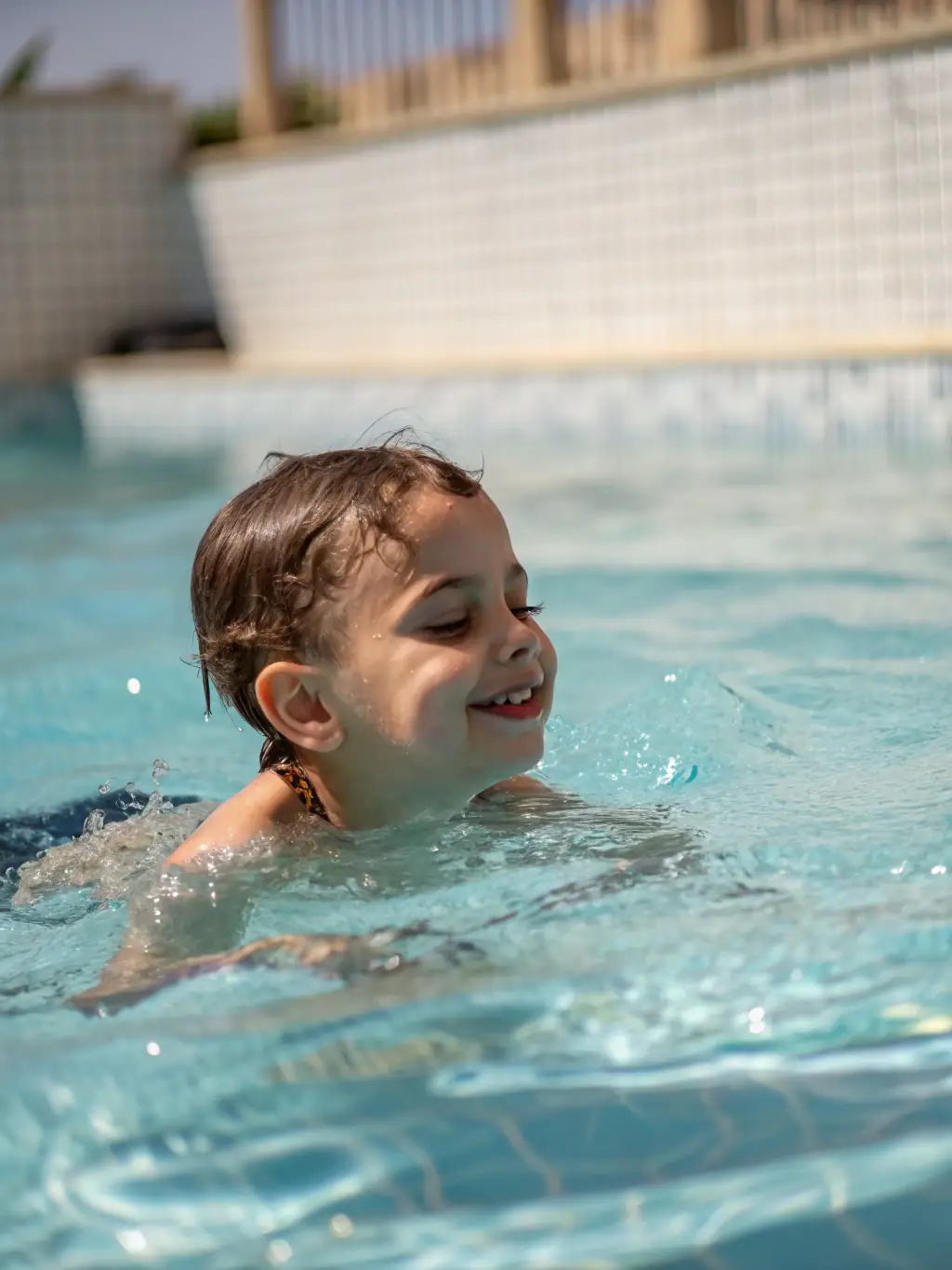 A student smiling confidently after completing a UNSS swimming competition, demonstrating personal growth and achievement.