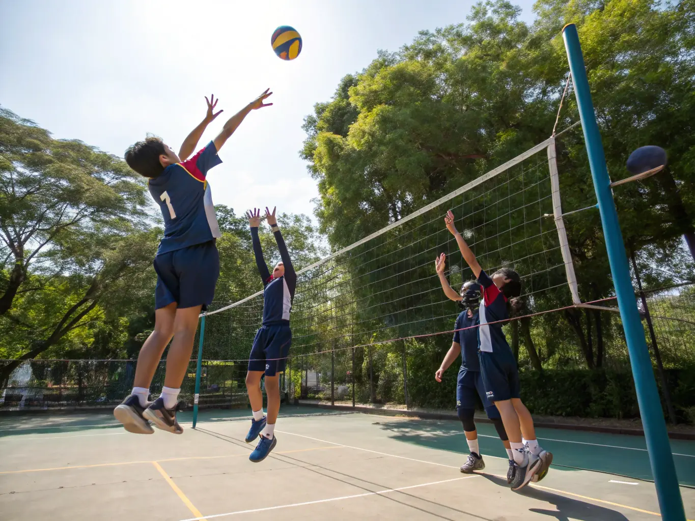 A photo of students participating in a volleyball match, emphasizing the collaborative and dynamic nature of UNSS's volleyball program.
